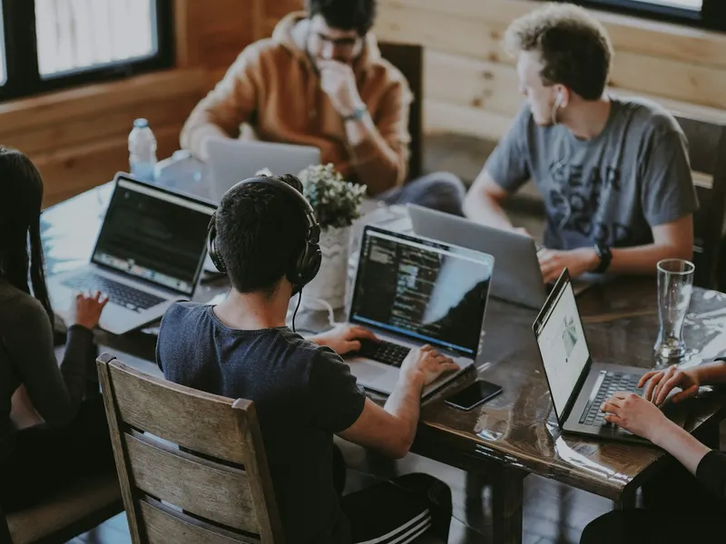 Trois personnes travaillent ensemble autour d'un ordinateur portable dans un bureau lumineux